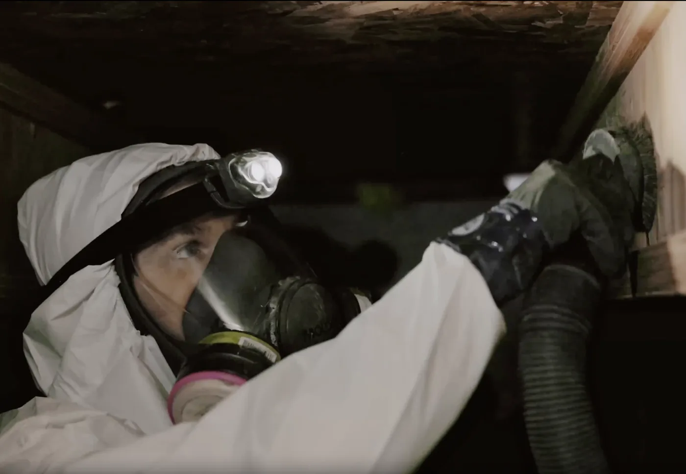 Master Restoration technician in protective gear working in a crawl space